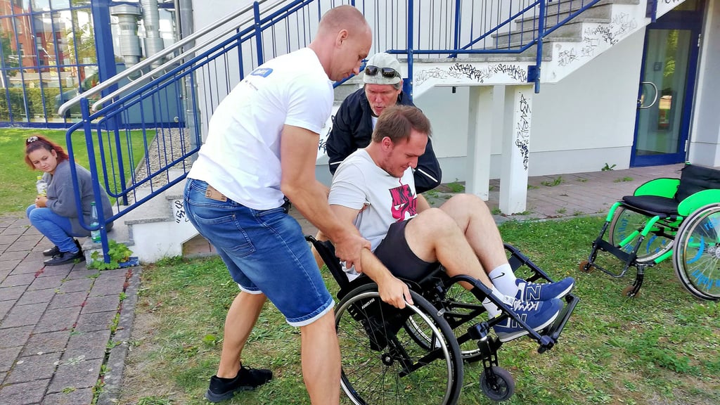 Robert Strohschein (vorn) und Volker Möws zeigten, wie man einen umgekippten Rollstuhlfahrer wieder aufhilft. Nick Kronawitt spielt mit.