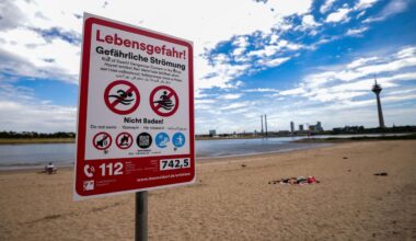 Nordrhein-Westfalen, Düsseldorf: Ein Hinweisschild am Paradiesstand in Düsseldorf weist auf die Gefahren beim Schwimmen im Rhein hin.
