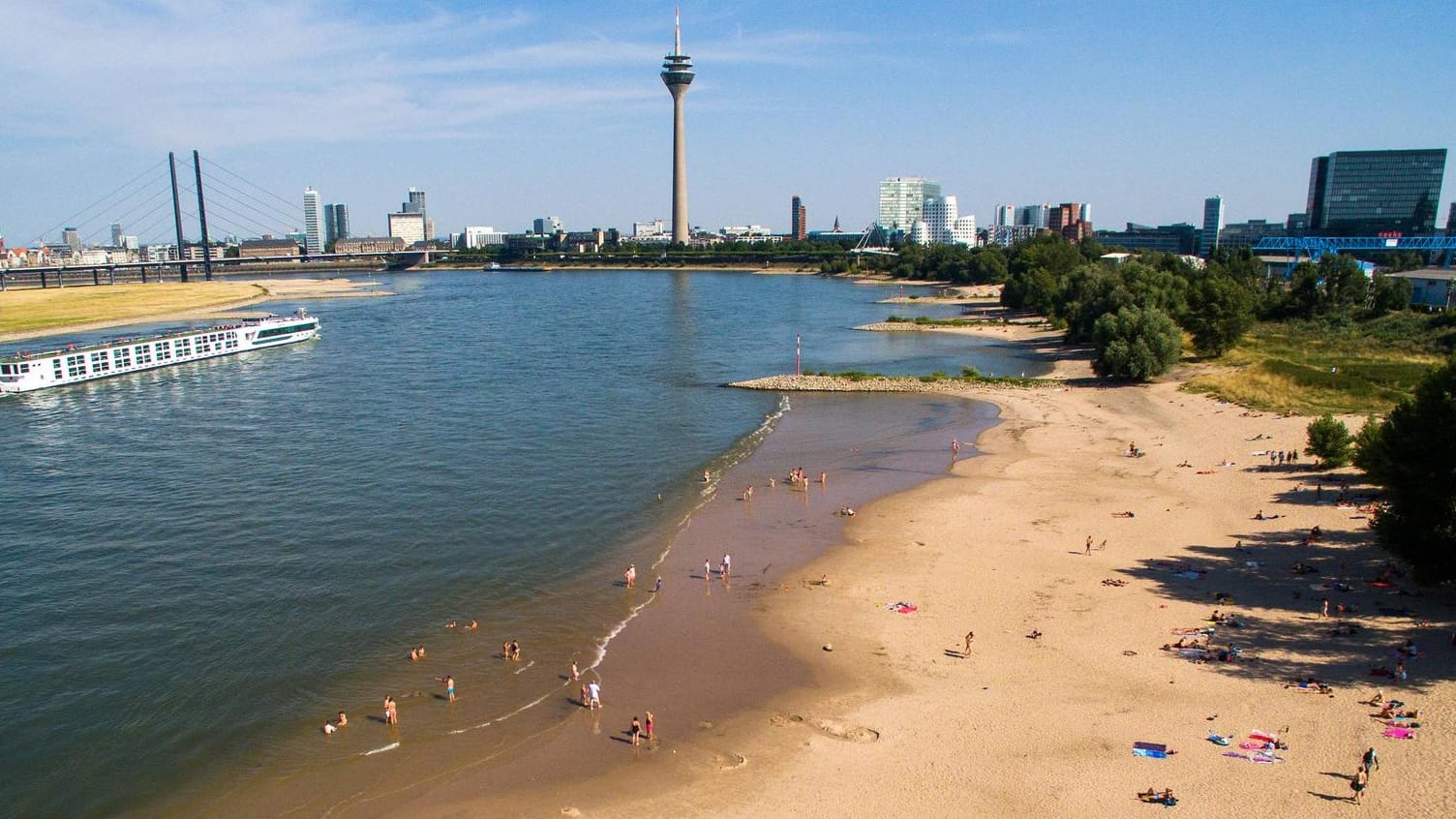 Blick auf den Düsseldorfer Paradiesstrand: Hier kann bei warmem Wetter am Strand entspannt und im Wasser geplantscht werden.