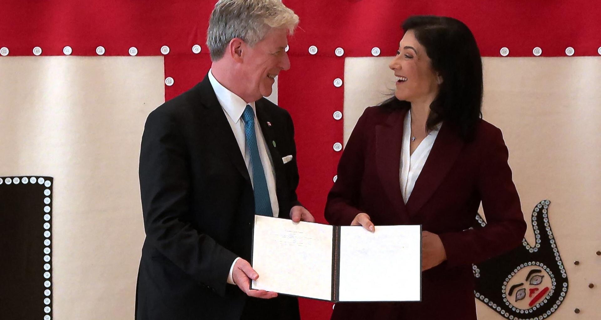 Bundeswirtschaftsministerin Reiche und der kanadische Energieminister Hodgson halten gemeinsam ein Schriftstück fest und lachen sich an.