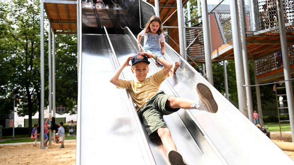 Auf der großen Rutsche können mehrere Kinder gleichzeitig nach unten sausen, hier Benjamin und Emilia.