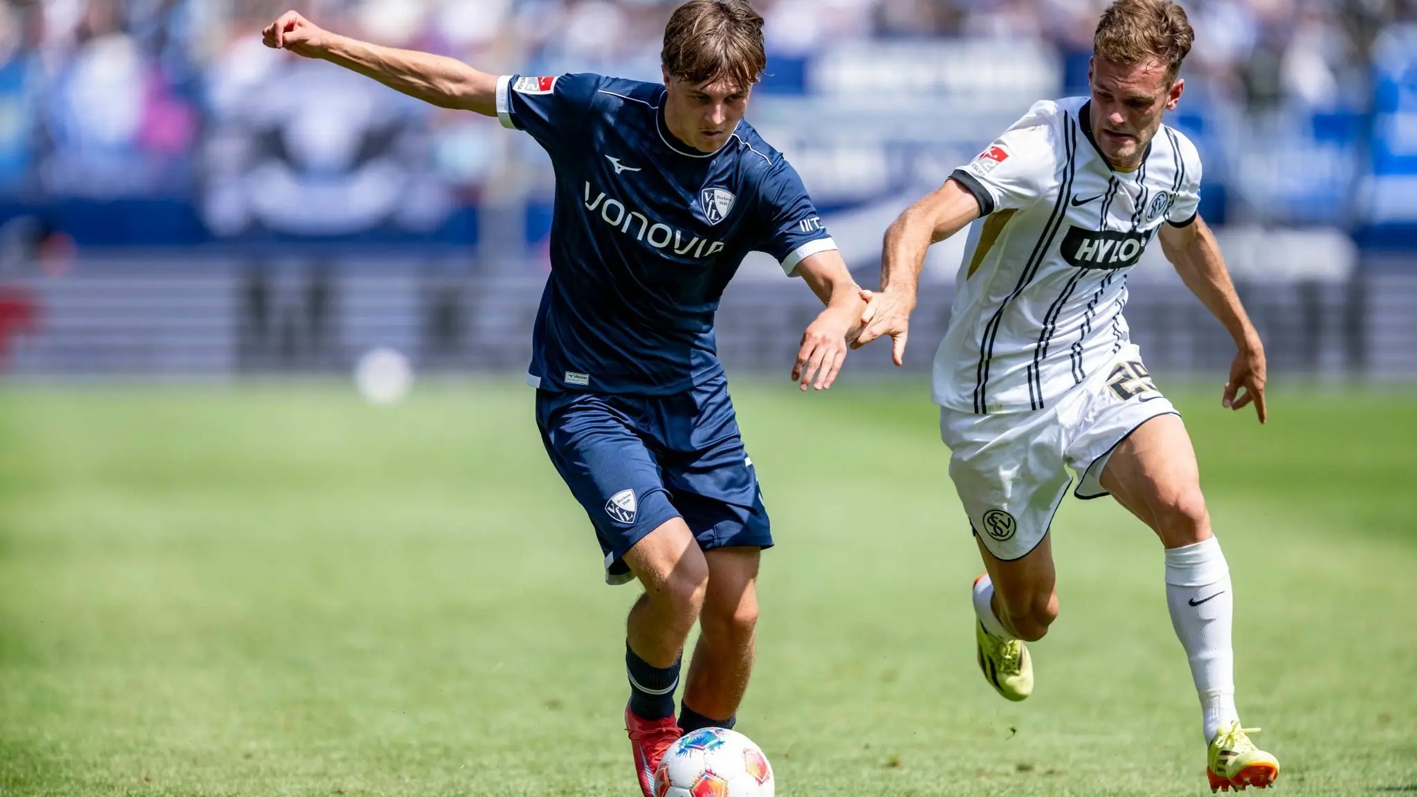 VfL Bochum - SV Elversberg: 10.08.2025, Nordrhein-Westfalen, Bochum: Fußball, 2. Bundesliga, VfL Bochum - SV Elversberg, 2. Spieltag, Vonovia Ruhrstadion: Kacper Koscierski (l, VfL Bochum) und Tom Zimmerschied (SV 07 Elversberg) kämpfen um den Ball. Foto: David Inderlied/dpa - WICHTIGER HINWEIS: Gemäß den Vorgaben der DFL Deutsche Fußball Liga bzw. des DFB Deutscher Fußball-Bund ist es untersagt, in dem Stadion und/oder vom Spiel angefertigte Fotoaufnahmen in Form von Sequenzbildern und/oder videoähnlichen Fotostrecken zu verwerten bzw. verwerten zu lassen. +++ dpa-Bildfunk +++