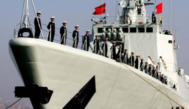 Soldaten stehen aufgereiht an der Reling eines chinesischen Kriegsschiffs.