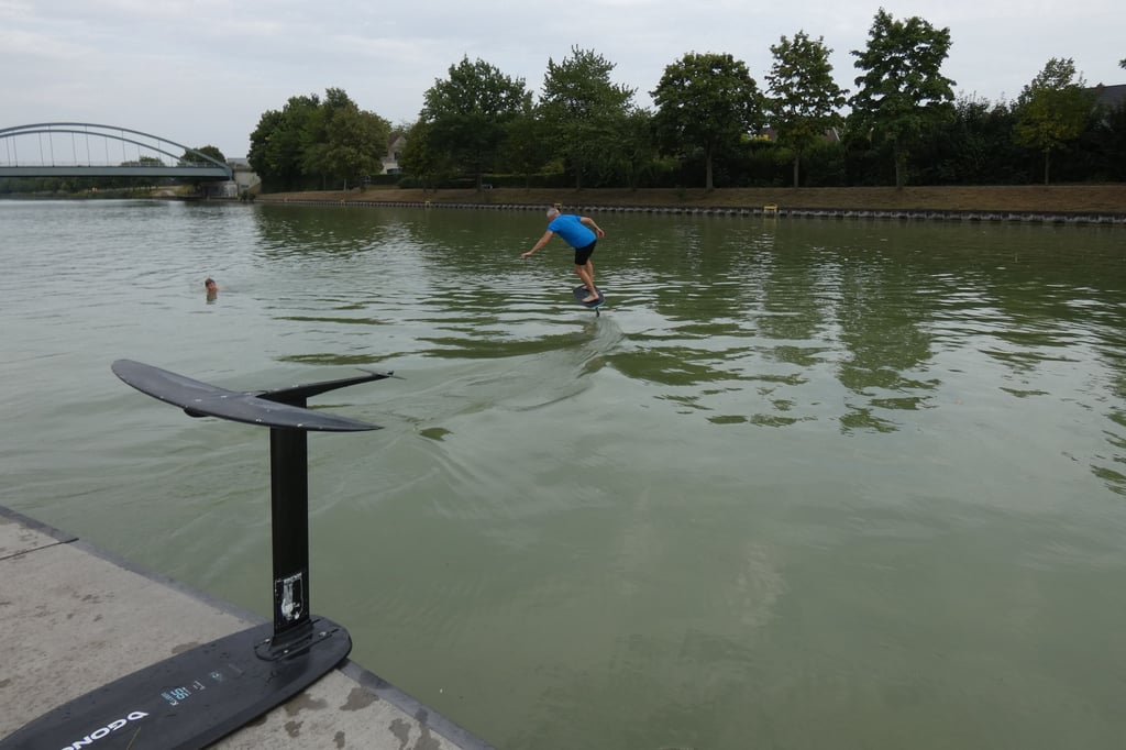 Sportler fahren mit Foilboards auf dem Kanal in Senden