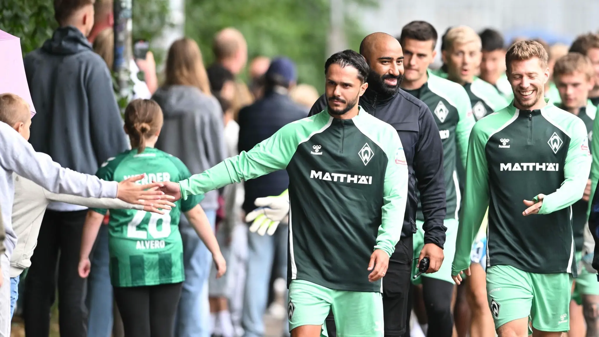 Trainingsauftakt Werder Bremen: 07.07.2025, Bremen: Fußball: Bundesliga, Trainingsauftakt von Werder Bremen, Werders Leonardo Bittencourt begrüßt auf dem Weg zum ersten Training die Fans. Foto: Carmen Jaspersen/dpa - WICHTIGER HINWEIS: Gemäß den Vorgaben der DFL Deutsche Fußball Liga bzw. des DFB Deutscher Fußball-Bund ist es untersagt, in dem Stadion und/oder vom Spiel angefertigte Fotoaufnahmen in Form von Sequenzbildern und/oder videoähnlichen Fotostrecken zu verwerten bzw. verwerten zu lassen. +++ dpa-Bildfunk +++