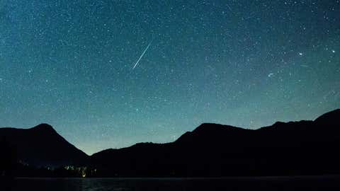12.08.2018, Bayern, Einsiedl: Eine Sternschnuppe leuchtet neben der Milchstraße am Himmel über dem Walchensee. Jahr für Jahr kreuzt die Erde auf ihrer Bahn um die Sonne Mitte November die Spur eines Kometen und am Nachthimmel erscheinen die Sternschnuppen der Leoniden. (Matthias Balk/dpa)

