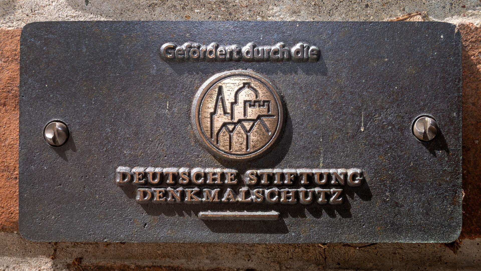 Ein Schild mit dem Schriftzug "Gefördert durch die Deutsche Stiftung Denkmalschutz" hängt im Eingangsbereich des evangelischen Dom St. Nikolai. 