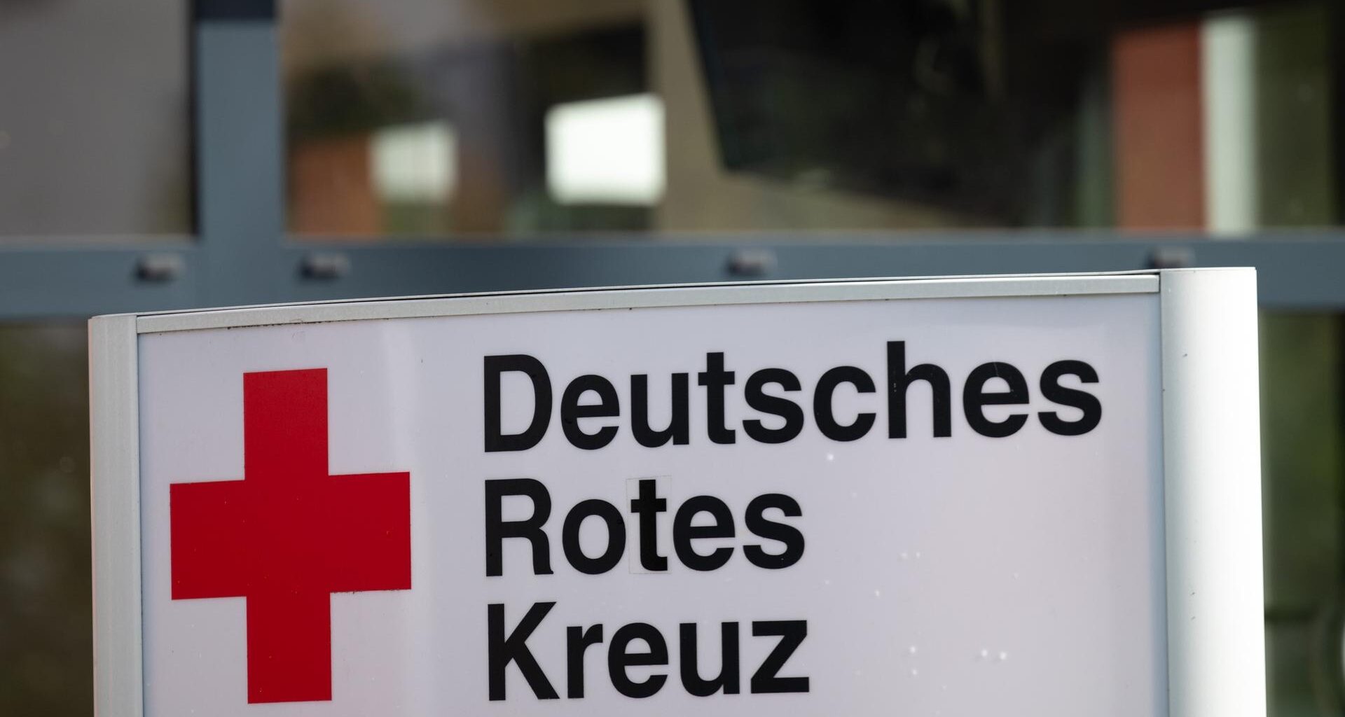 Ein Schild mit der Aufschrift "Deutsches Rotes Kreuz" (DRK) steht vor dem Eingang eines Hauses.