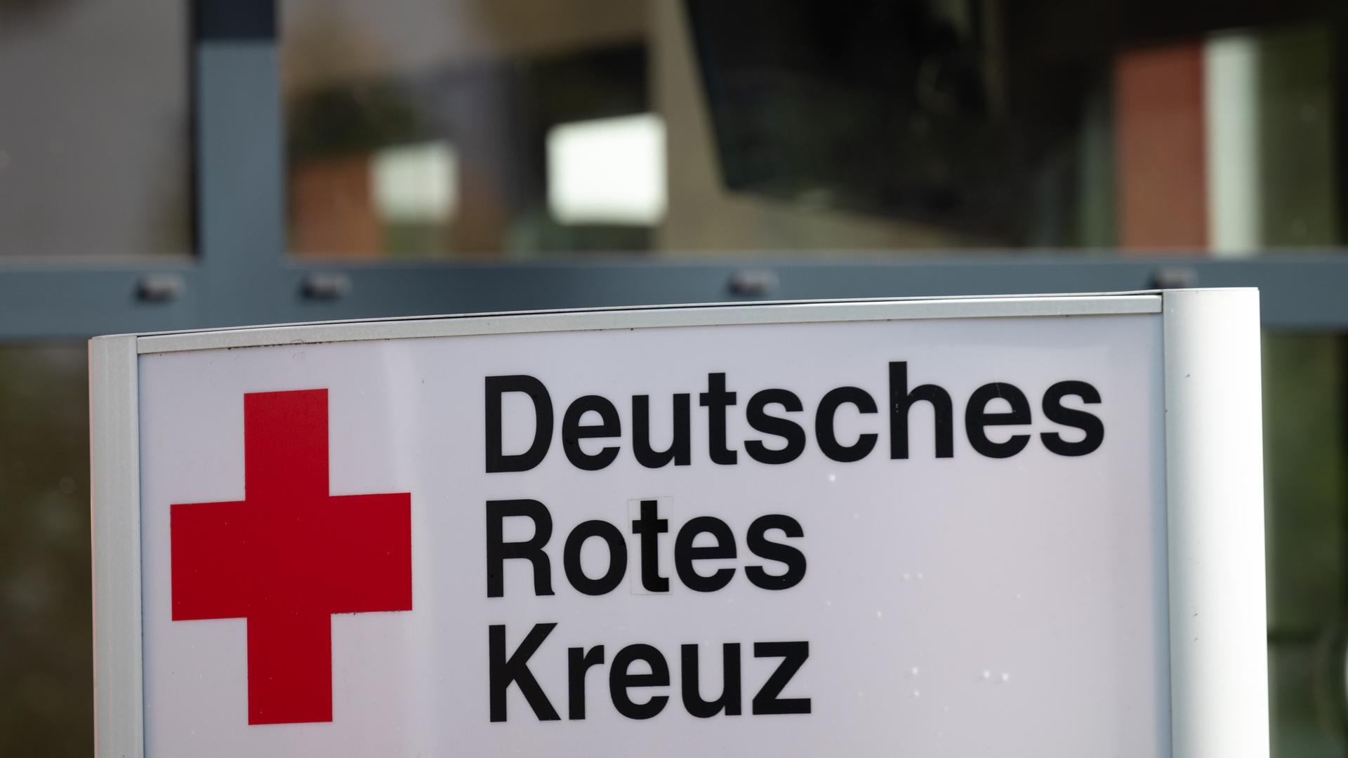 Ein Schild mit der Aufschrift "Deutsches Rotes Kreuz" (DRK) steht vor dem Eingang eines Hauses.