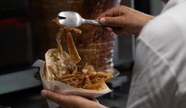 Ein Mitarbeiter füllt Dönerfleisch in ein Fladenbrot