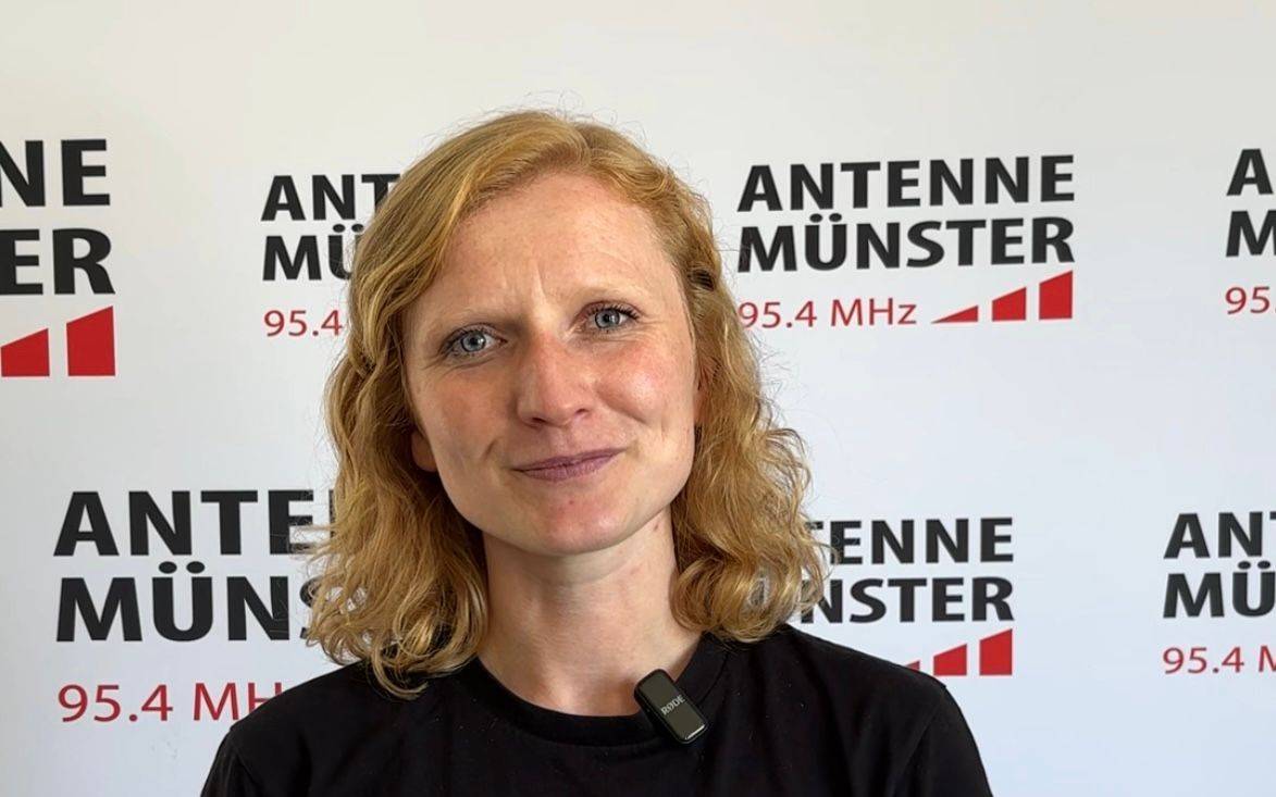 Katharina Martinewski, eine Frau mit orange-roten, schulterlangen Haaren.