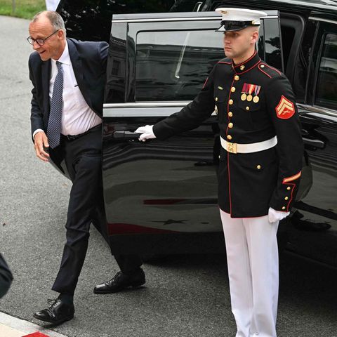 Friedrich Merz steigt aus einem Auto aus, im Vordergrund sind Soldaten und eine amerikanische Flagge zu sehen