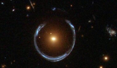 Ein Bild eines Einsteinrings, einer astronomischen Erscheinung, bei der das Licht einer entfernten Galaxie durch die Gravitationskraft einer näheren Galaxie gebogen wird, wodurch ein ringförmiges Muster entsteht. Im Zentrum des Bildes befindet sich eine helle, gelbliche Galaxie, umgeben von einem bläulichen Lichtbogen. Mehrere kleinere Lichtpunkte, die entfernte Sterne oder Galaxien darstellen, sind im Hintergrund zu sehen. Das Bild veranschaulicht das Phänomen der Gravitationslinsen in der Astronomie.