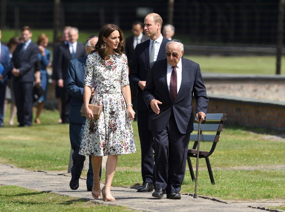 William und Kate, wie sie ein Konzentrationslager besuchen. 