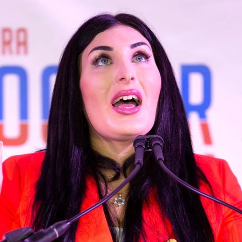 Laura Loomer hebt beide Hände empor