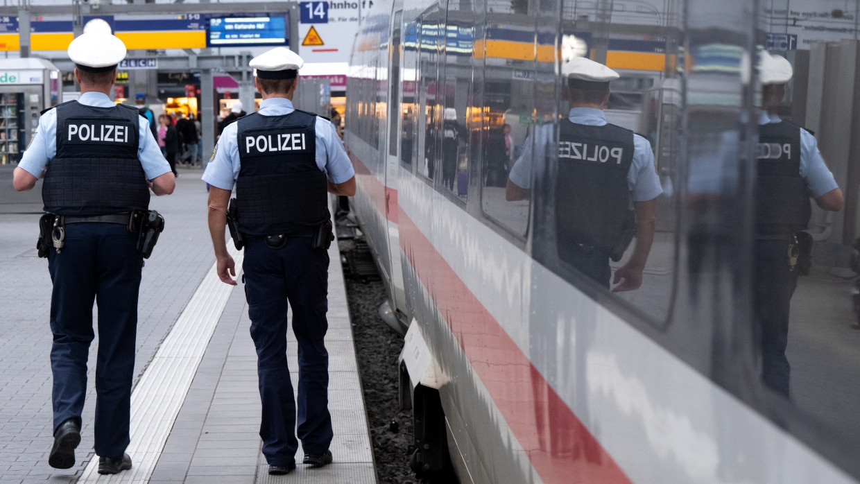 Polizeibeamte laufen an einem ICE entlang (Symbolbild).