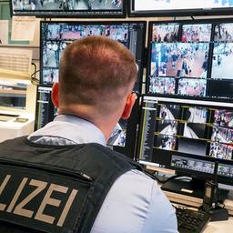 Symbolbild: Ein Polizist vor den Überwachungsmonitoren (Quelle: dpa)