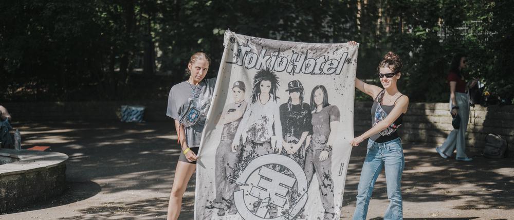 Was wäre ein Konzert ohne Transpi? Vor dem Westeingang der Parkbühne Wuhlheide warten Louanne und Charlotte auf die Band.