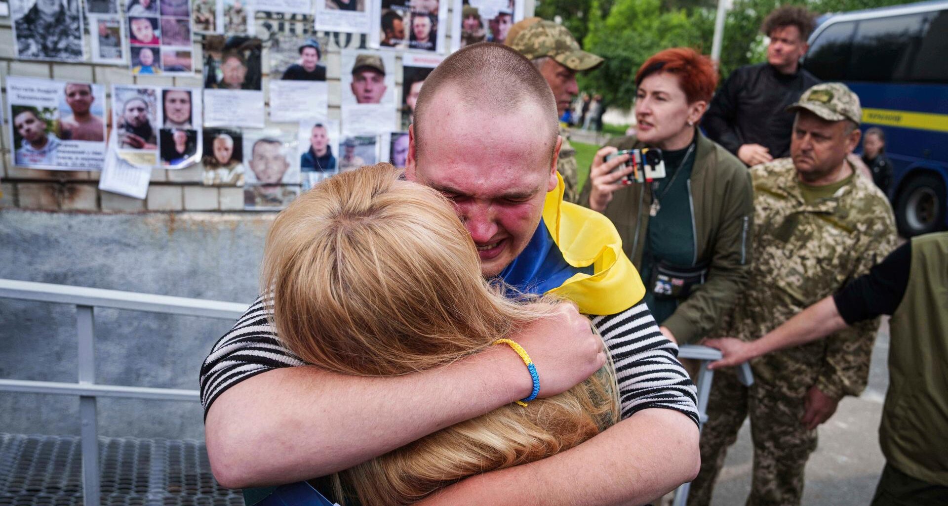 Ein ukrainischer Soldat weint und umarmt seine Mutter. Dahinter weitere Personen.