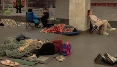 Menschen sitzen oder liegen in einer U-Bahn-Station in Kiew.