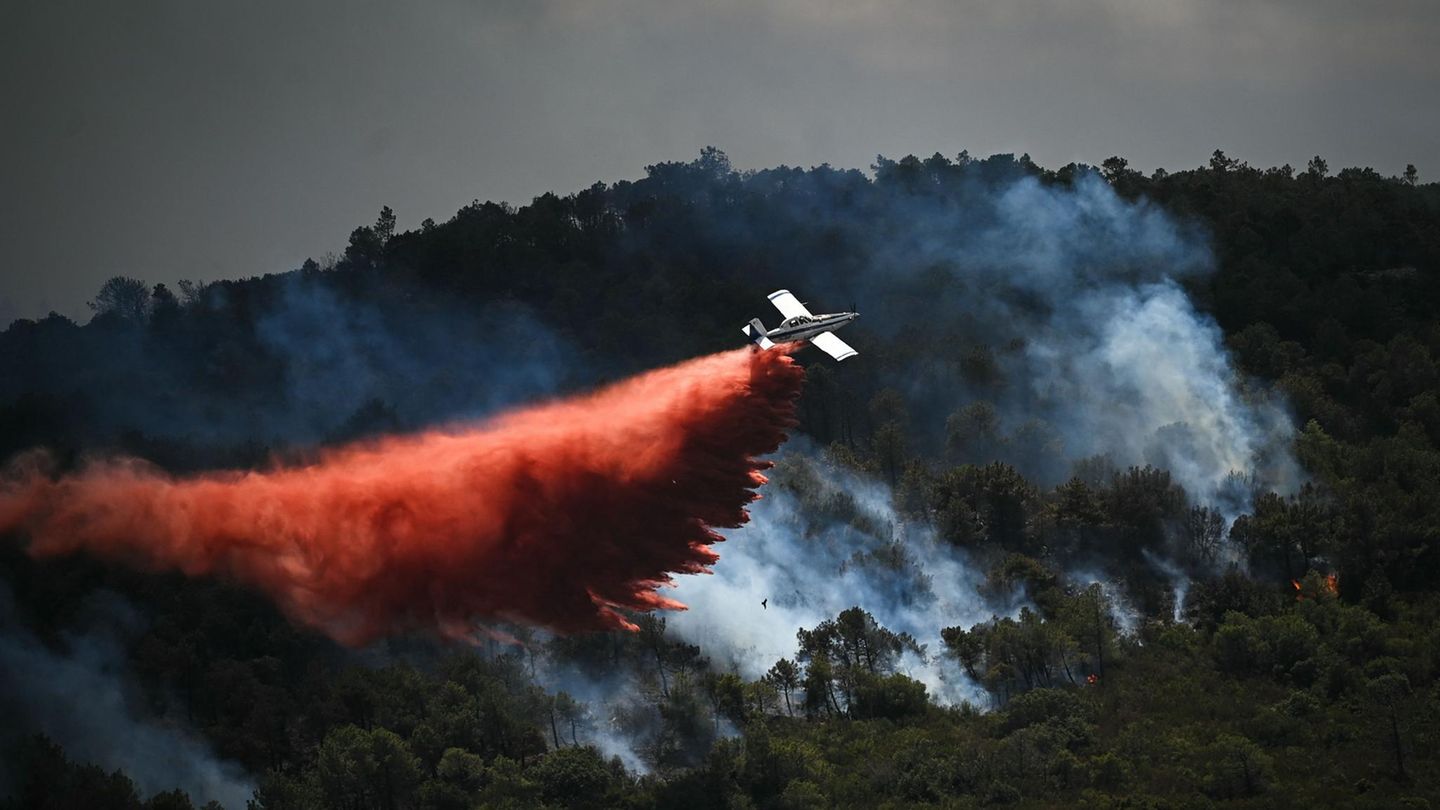 Ein Löschflugzeug wirft in Südfrankreich Löschmittel über einem Waldbrand ab