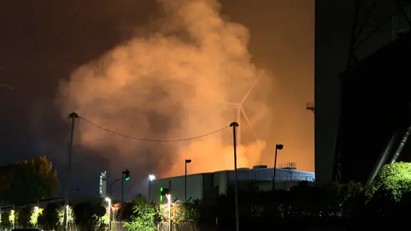 Flammen erleuchten den nächtlichen Himmel über dem Stahlwerk. 
