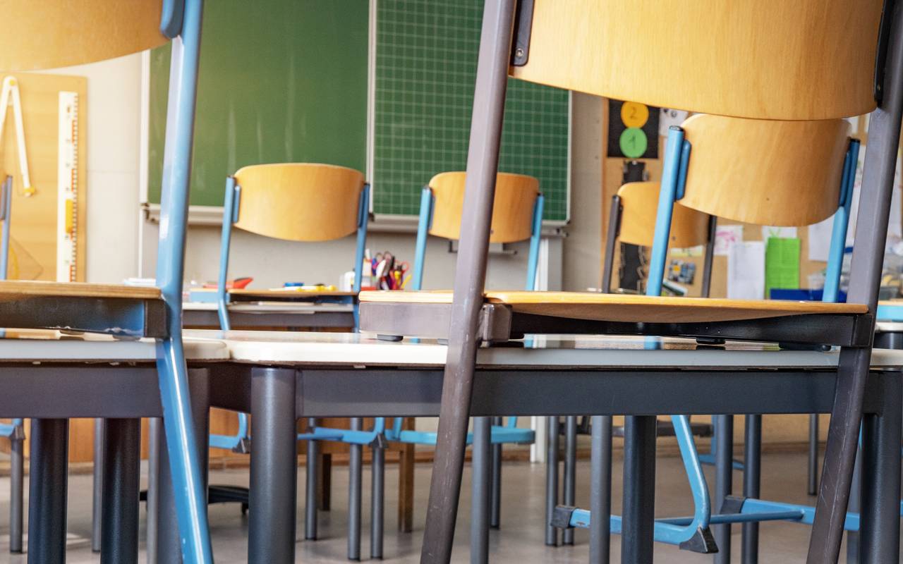 Leeres Klassenzimmer mit hohen Stühlen und leerer Tafel.