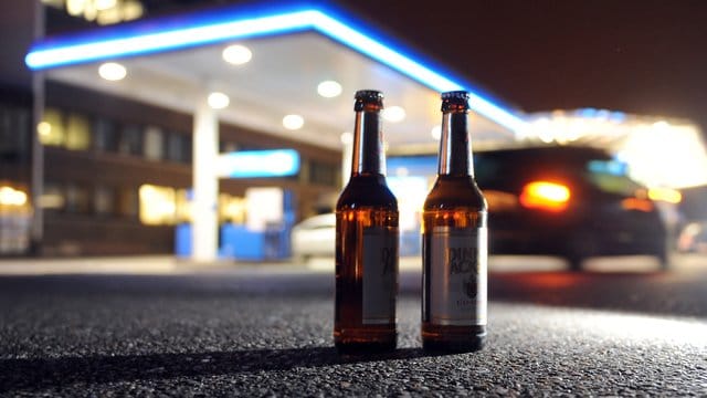 Zwei Bierflaschen vor einer Tankstelle