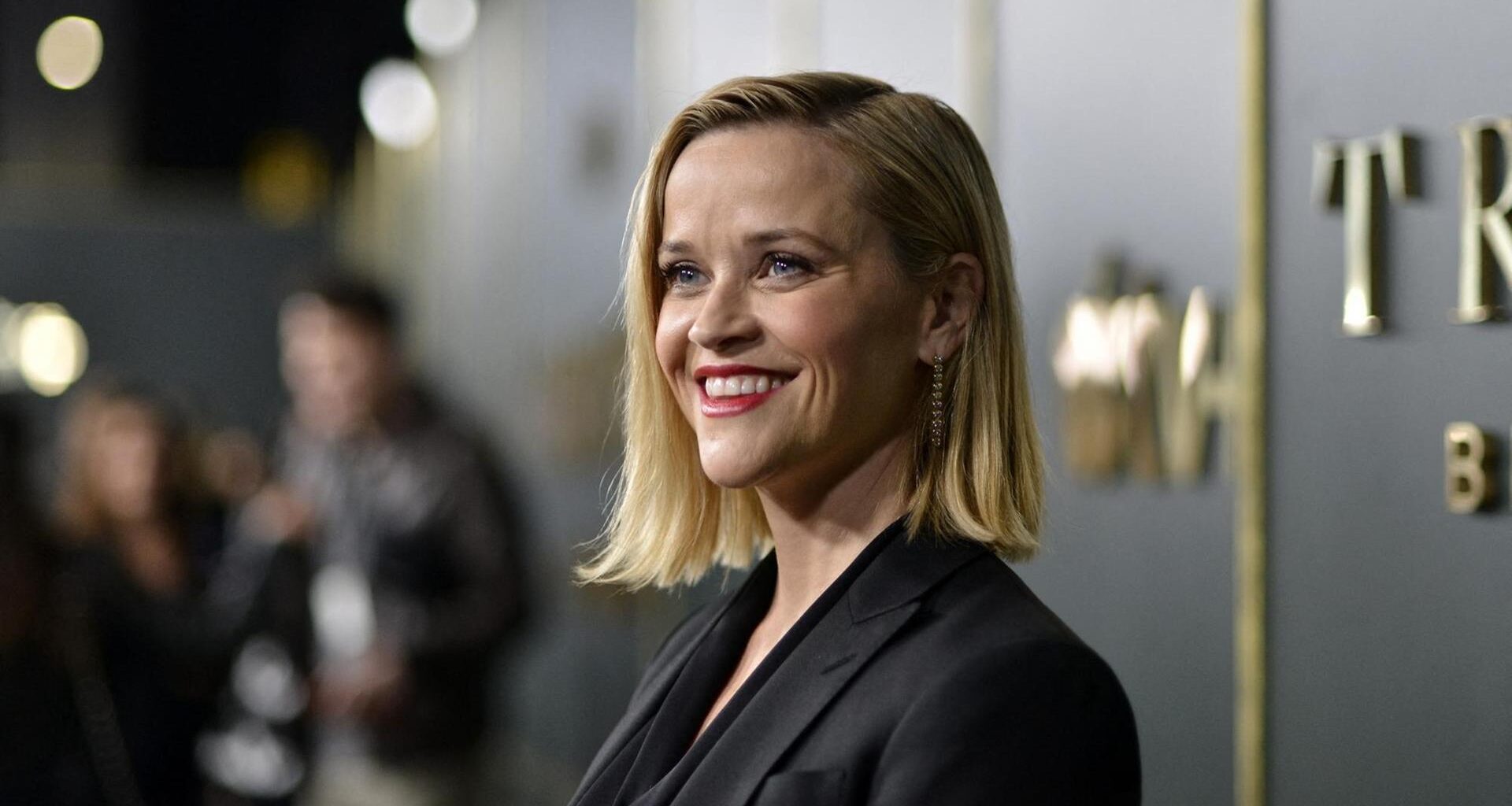 Porträt von Reese Witherspoon lächelnd auf dem roten Teppich.