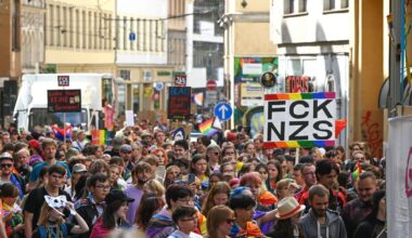 Teilnehmende des CSD ziehen mit Regenbogenfahnen und Plakaten durch die Innenstadt von Halle. Foto: Heiko Rebsch/dpa