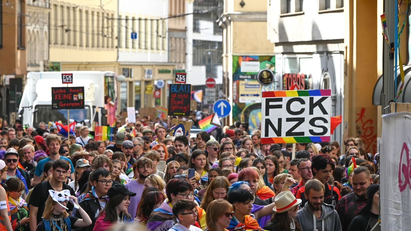 Teilnehmende des CSD ziehen mit Regenbogenfahnen und Plakaten durch die Innenstadt von Halle. Foto: Heiko Rebsch/dpa