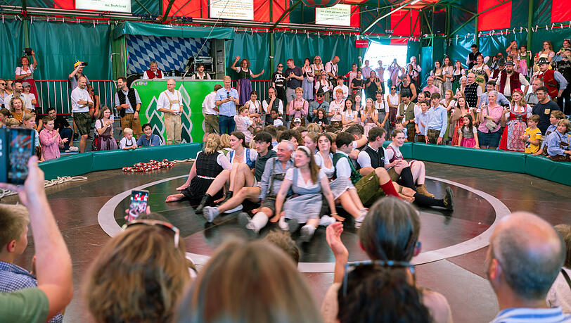 Besucherinnen und Besucher sitzen auf dem Teufelsrad auf dem Oktoberfest. Besucherinnen und Besucher sitzen auf dem Teufelsrad auf dem Oktoberfest.