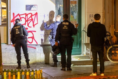 Brennende Barrikaden am Karli sorgen für Aufregung - Polizeibeamte dokumentieren Farbschmierereien an einer Hauswand nahe des Brandortes. Foto: EHL Media
