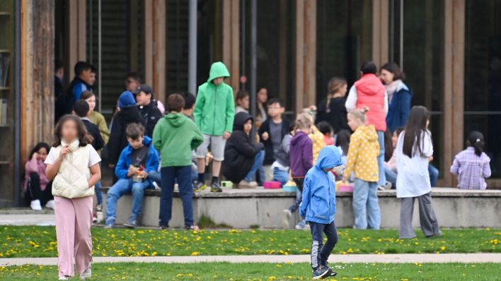 Symbolbild: Schueler*innen halten sich in der grossen Pause auf dem Schulhof einer Grundschule auf. (Quelle: dpa/Simon)