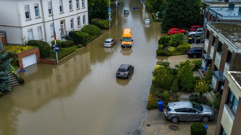 Autos stehen in den Wassermassen in einer überschwemmten Straße in Mönchengladbach-Rheydt. 