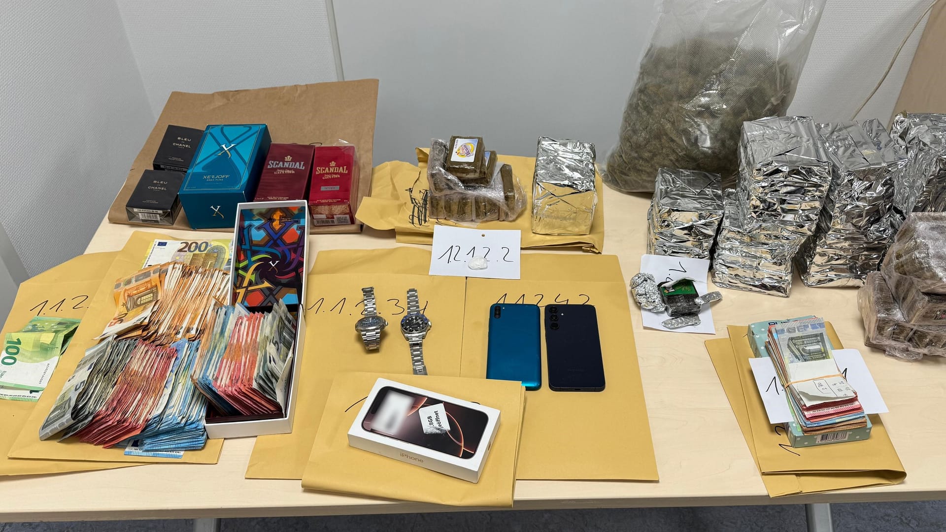 Geld, Drogen, Uhren und Parfüm auf einem Tisch: Die Polizei nahm zwei mutmaßliche Drogendealer fest.
