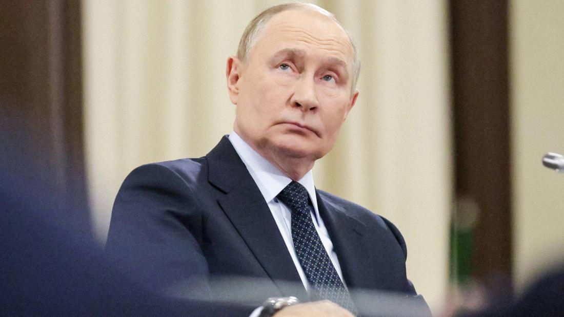 Wladimir Putin sitzt an einem Tisch und schaut nach oben