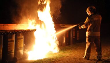 Ein Feuerwehrmann löscht einen brennenden Müllcontainer. Symbolbild - Foto: Roland Halkasch