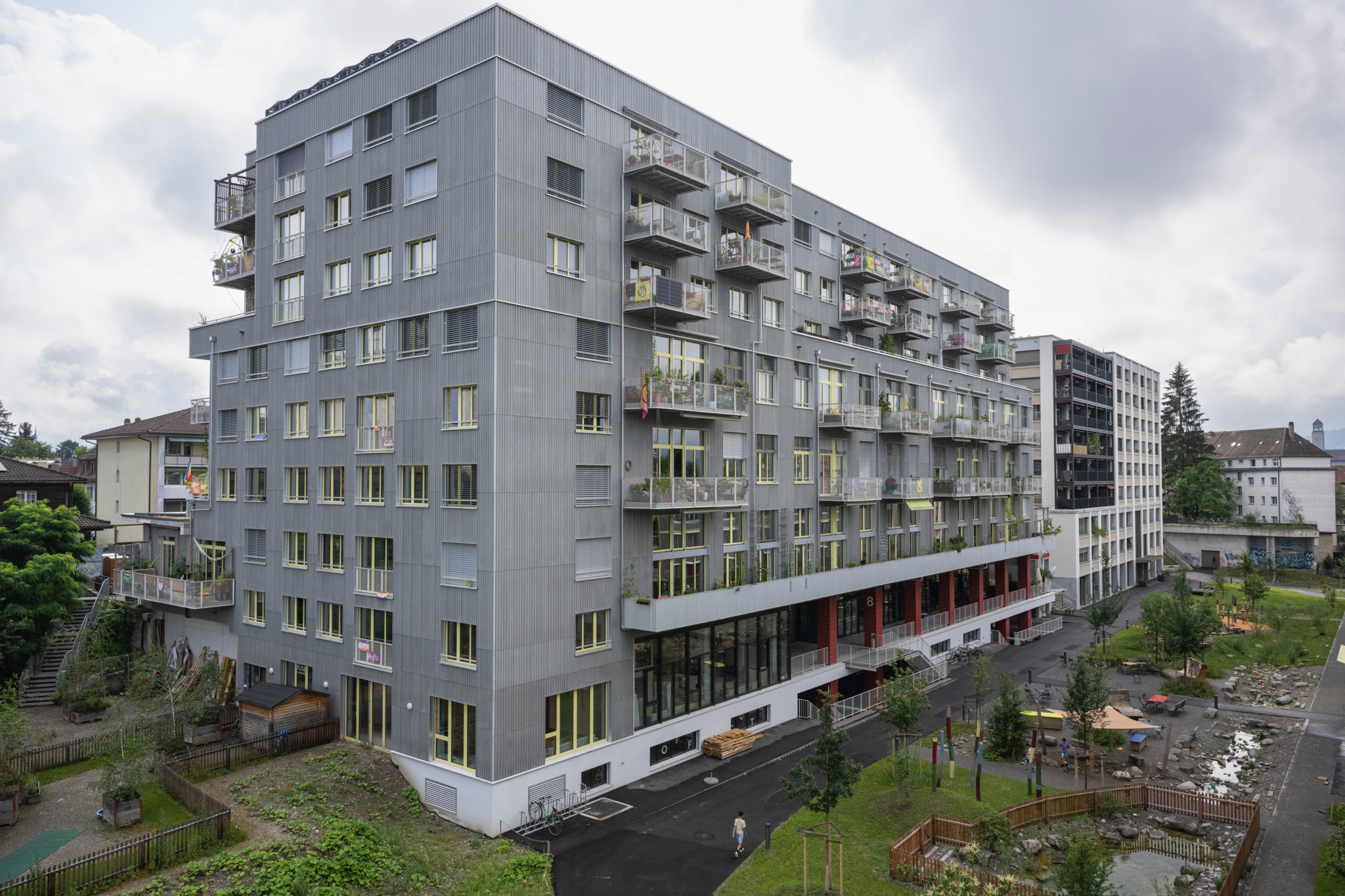 Aussenansicht der Wohnbaugenossenschaft Warmbächli in Bern, ein modernes mehrstöckiges Gebäude mit Balkonen.