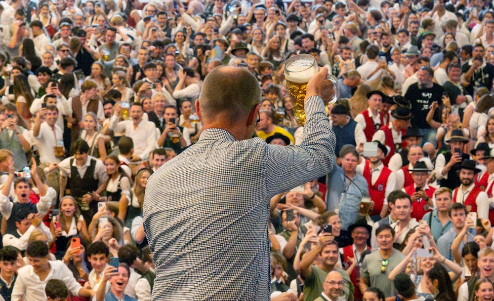 Premiere am zweiten Wiesn-Tag: Mit Friedrich Merz zeigt sich ein amtierender Bundeskanzler auf dem Oktoberfest und prostet von der Schottenhamel-Empore zu.