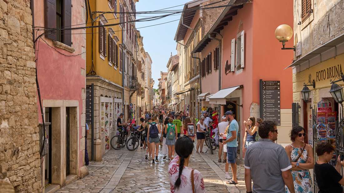 Die Altstadt von Porec in Kroatien ist ein beliebtes Ziel für Touristen, die durch enge, gepflasterte Straßen flanieren und die historische Architektur genießen. Die Menschenmengen in der Fußgängerzone zeigen die Anziehungskraft dieser malerischen Küstenstadt für Sommerurlauber.