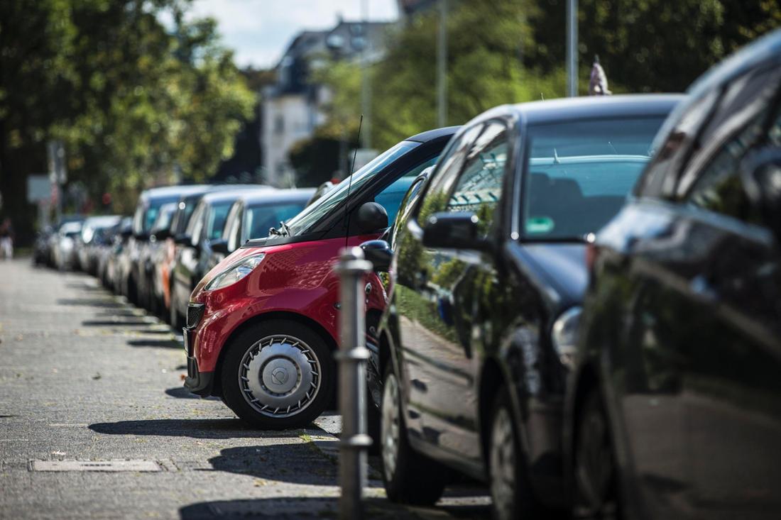 Autos stehen an einem Sommertag am Straßenrand in einer Reihe. 