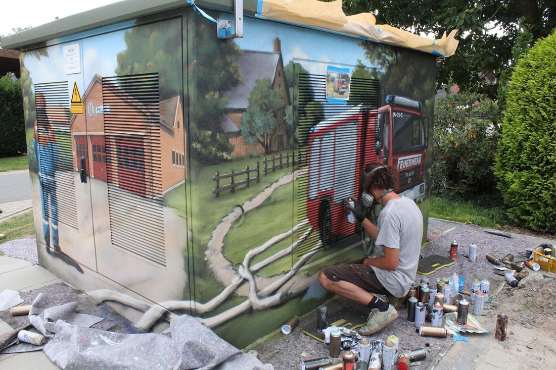 Graffiti-Künstler Nils Neumeyer bei den letzten Arbeiten an der Trafostation.