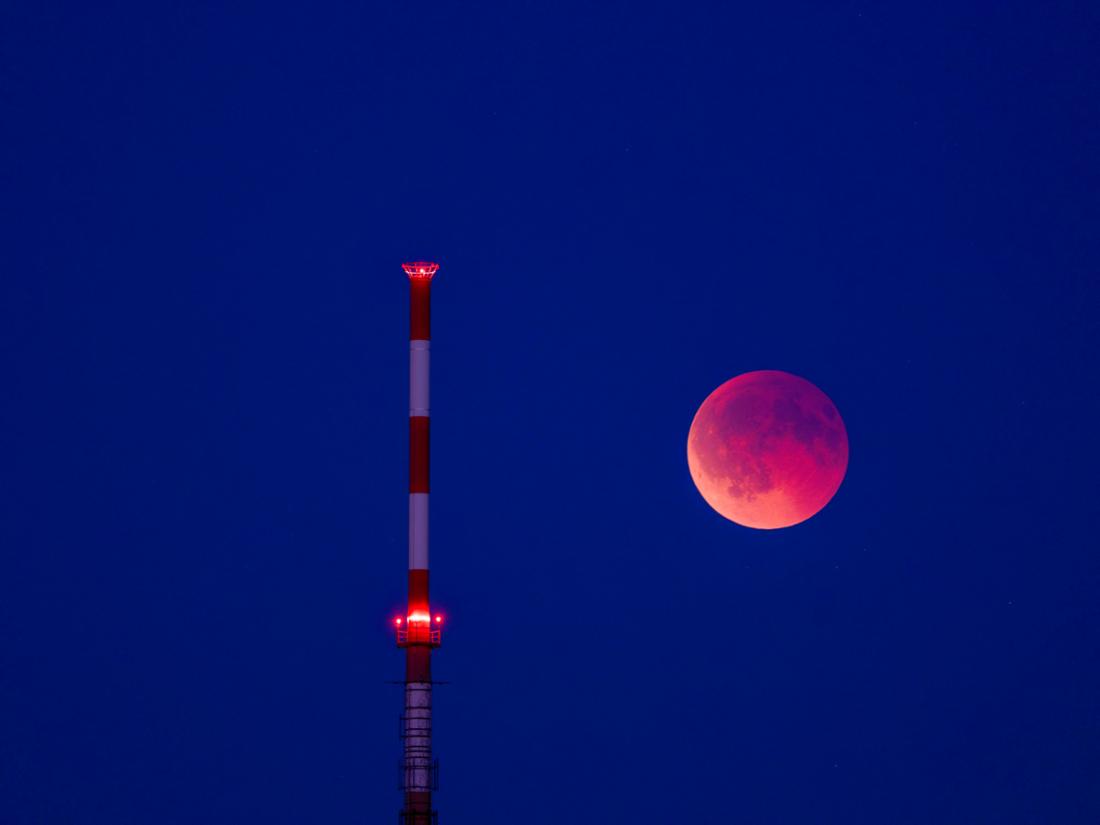Der Blutmond steht neben dem Fernsehturm in Braunschweig.