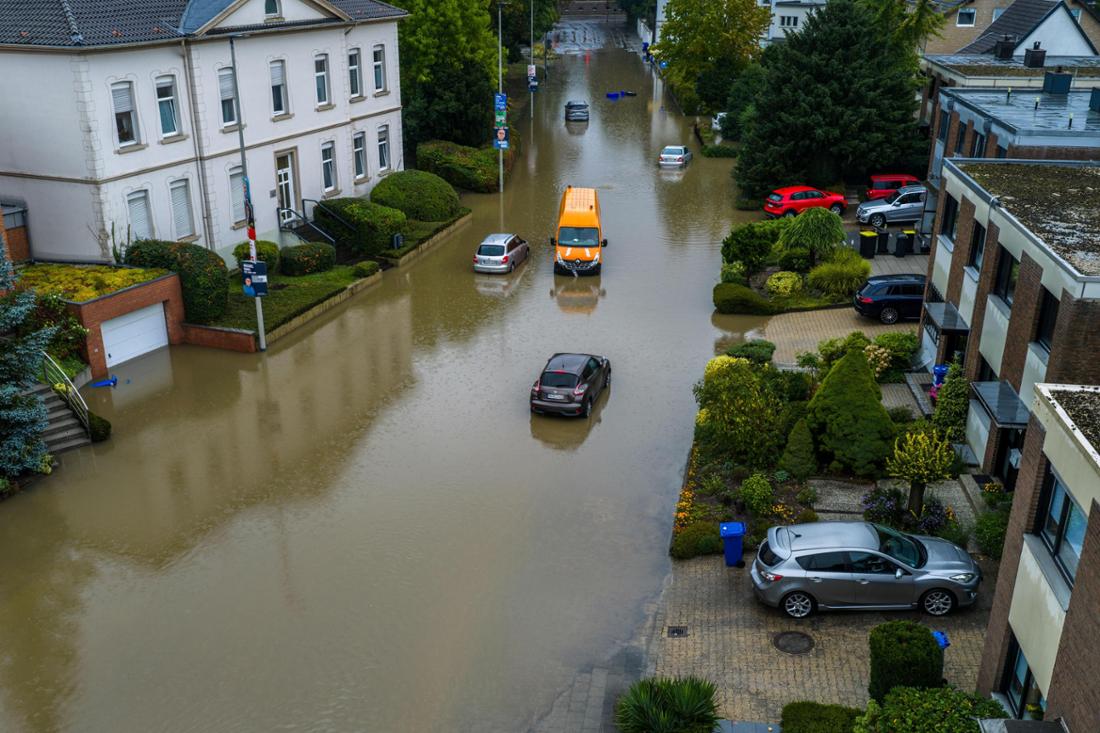 Autos stehen in den Wassermassen in einer überschwemmten Straße in Mönchengladbach-Rheydt.