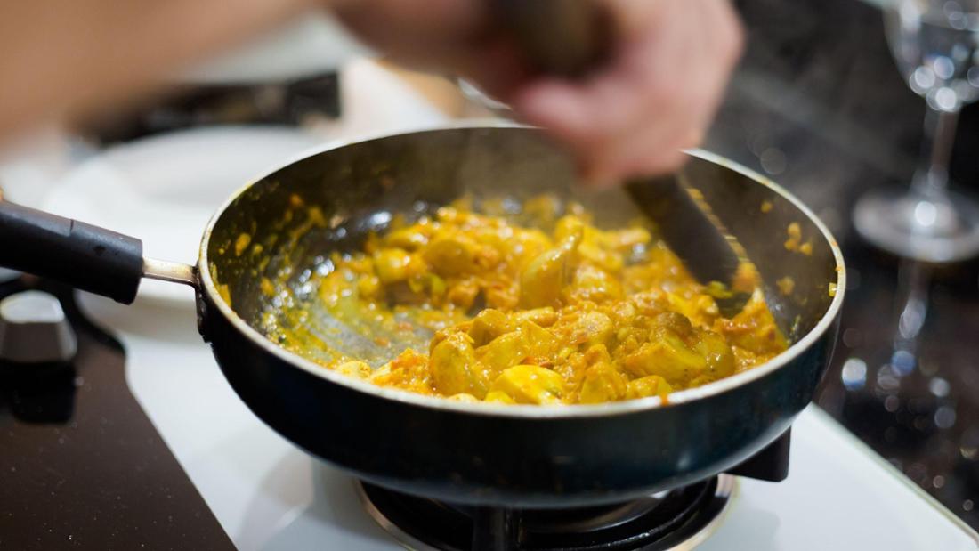 Ein Koch bereitet ein Curry zu