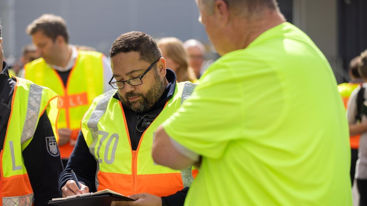 Zöllner Ingo Bahr von der FKS befragt bei der Kontrolle im Hafen Lkw-Fahrer Frank Pietsch.