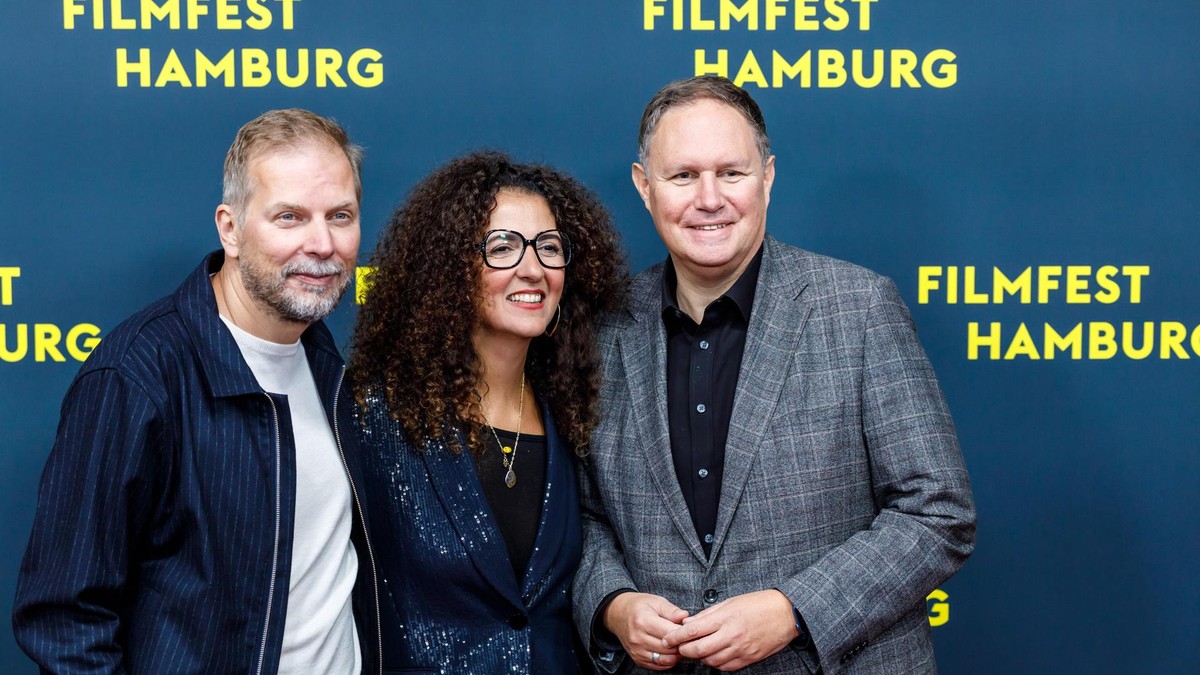 Auf dem roten Teppich des Filmfests Hamburg waren nicht nur Schauspieler zu sehen. Auch Produzent und Geschäftsführer der Filmförderung Hamburg Helge Albers (links) ließ sich gemeinsam mit Filmfest-Leiterin Malika Rabahallah (Mitte) und Kultursenator Carsten Brosda bei der Eröffnung blicken. Filmfest 2025