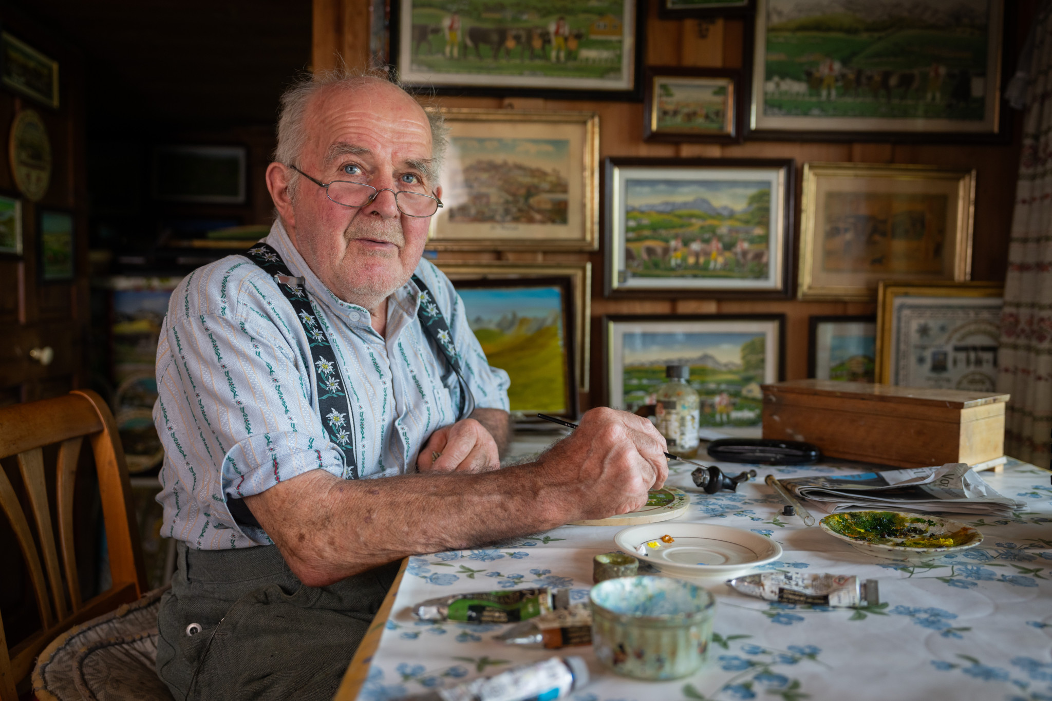 Bauernmaler Johann Hautle sitzt an einem Tisch in seinem Haus in Gonten.