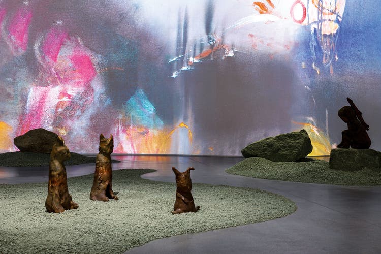Leiko Ikemura hat für das Kunstmuseum Chur einen Skulpturengarten entworfen und auf den Kiesinseln Bronzefiguren platziert. Rechts hinten sitzt das «Rocket Girl I» (2024). Auf der Rückwand ist ihre Videoinstallation «Nocturno Vivo» (2022) zu sehen.